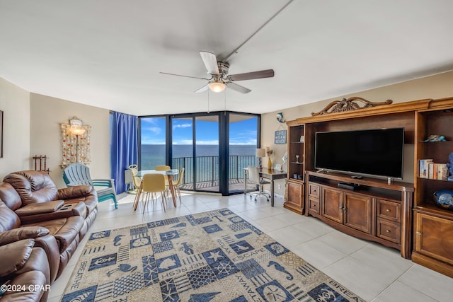 living room with floor to ceiling windows, ceiling fan, light tile floors, and a water view