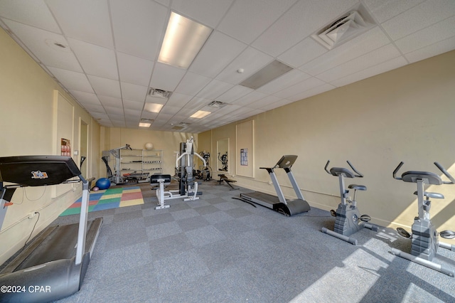 exercise area with a drop ceiling and carpet floors