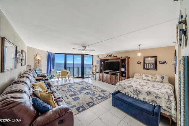 tiled bedroom featuring floor to ceiling windows, ceiling fan, and a water view