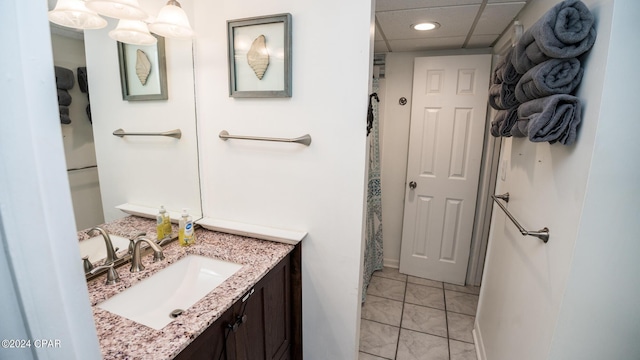 bathroom with vanity, a paneled ceiling, and tile patterned floors