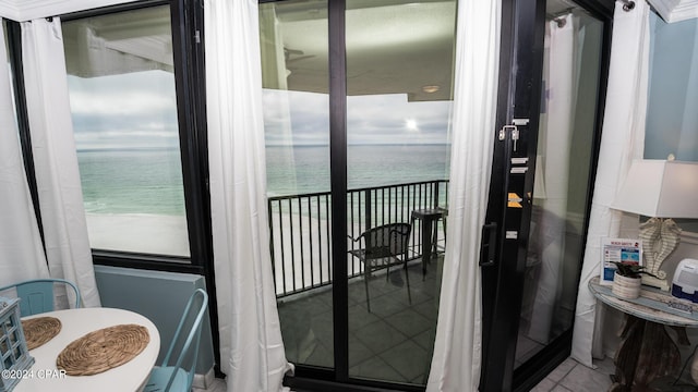 balcony with a water view and a view of the beach