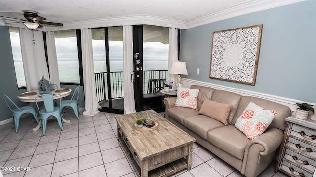 living room with crown molding, a water view, light tile patterned floors, and ceiling fan