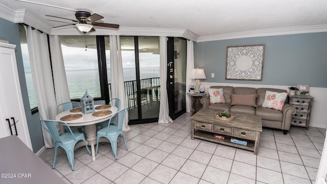 tiled living room with a water view, ceiling fan, plenty of natural light, and crown molding