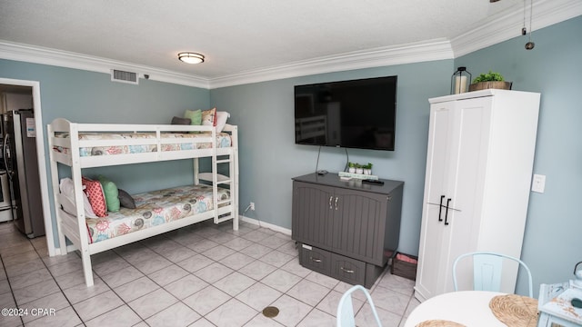 bedroom featuring crown molding, light tile patterned floors, and stainless steel fridge