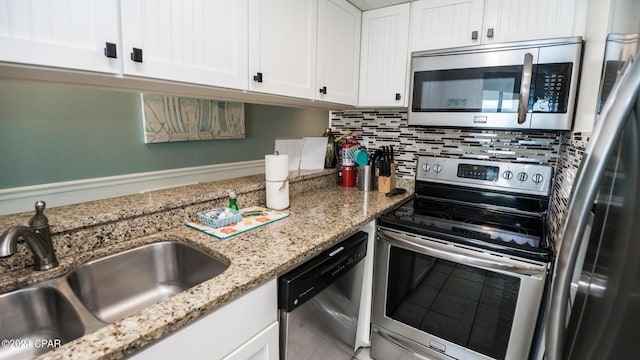 kitchen featuring sink, backsplash, white cabinets, light stone counters, and stainless steel appliances