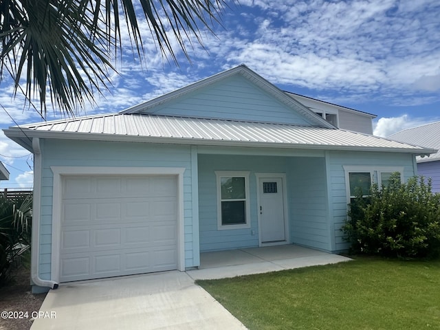 view of front of house featuring metal roof and a front lawn