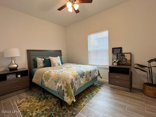 bedroom with wood tiled floor, ceiling fan, and baseboards