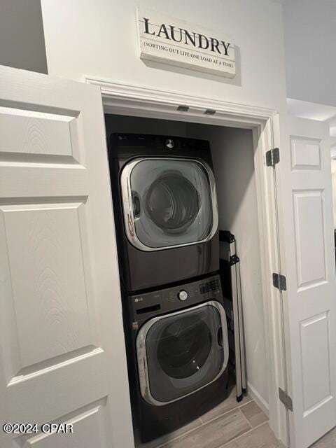 laundry area with stacked washer / drying machine and laundry area