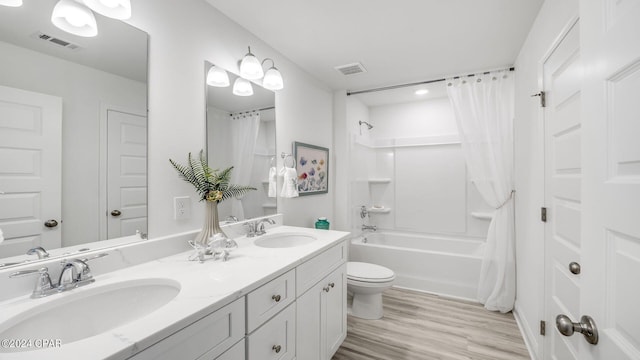 full bathroom with visible vents, wood finished floors, and a sink