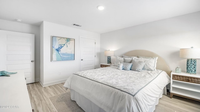 bedroom with recessed lighting, visible vents, baseboards, and light wood finished floors