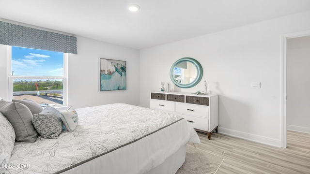 bedroom with light wood finished floors and baseboards