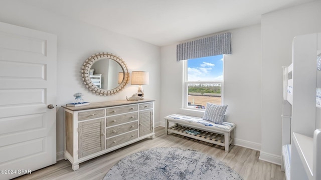 sitting room with baseboards and light wood-style floors