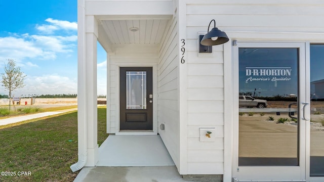 view of exterior entry featuring a yard