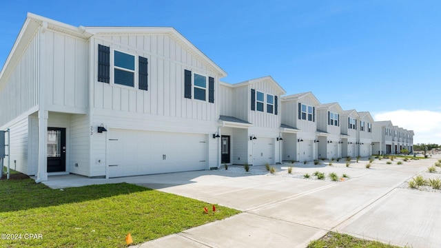 view of property featuring a garage and a front lawn