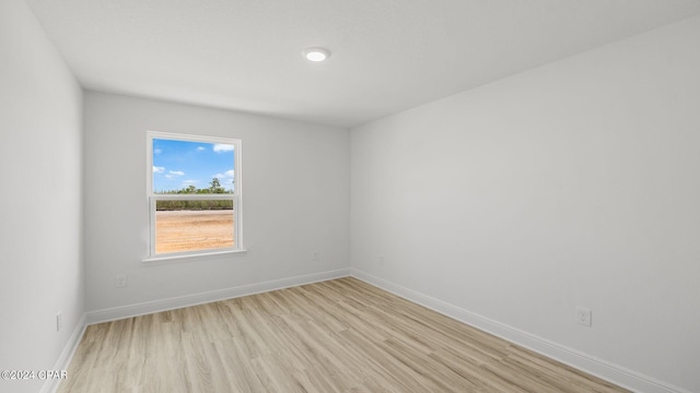 empty room with light wood-type flooring and baseboards