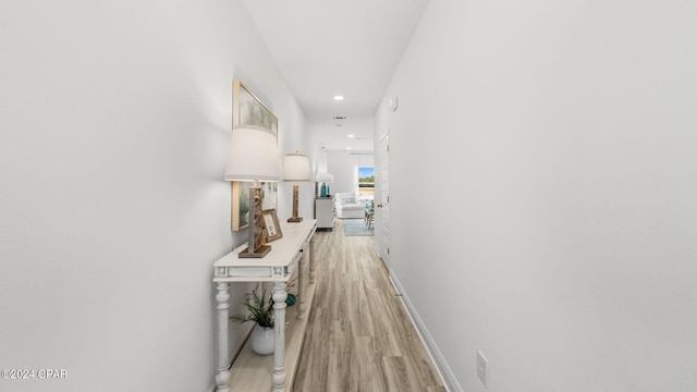 hallway with recessed lighting, baseboards, and light wood-style floors