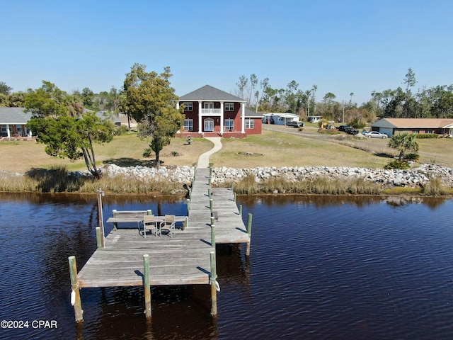 view of dock featuring a water view and a lawn