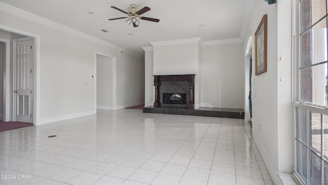 unfurnished living room with a fireplace with raised hearth, ceiling fan, light tile patterned floors, baseboards, and ornamental molding