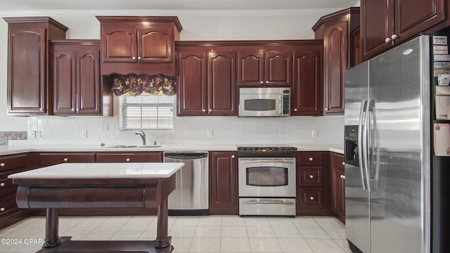 kitchen featuring stainless steel appliances, tasteful backsplash, a sink, and light countertops