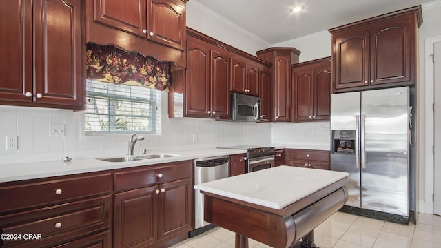 kitchen with a sink, light countertops, appliances with stainless steel finishes, tasteful backsplash, and crown molding