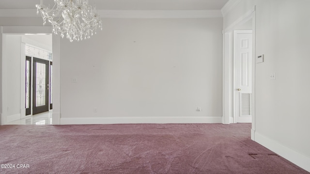 carpeted empty room featuring baseboards, french doors, ornamental molding, and a notable chandelier