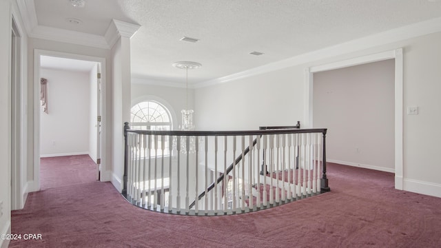 corridor featuring carpet floors, ornamental molding, a textured ceiling, an upstairs landing, and baseboards