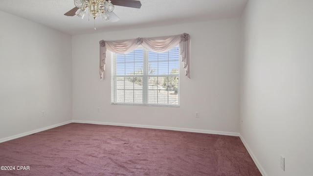 carpeted empty room featuring ceiling fan and baseboards