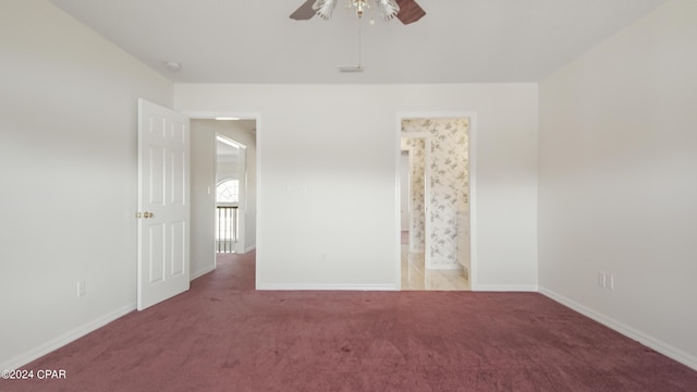 carpeted empty room featuring a ceiling fan and baseboards