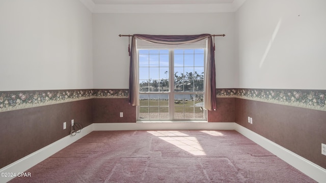 carpeted spare room featuring wainscoting, baseboards, and wallpapered walls