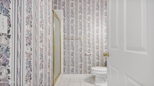 bathroom featuring a stall shower, wallpapered walls, toilet, and tile patterned floors