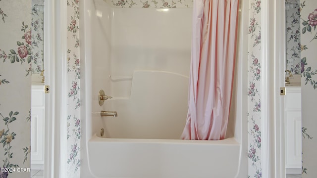 bathroom with wallpapered walls and shower / bath combination with curtain