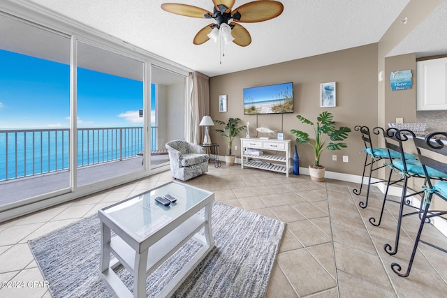 tiled living room featuring ceiling fan and a textured ceiling