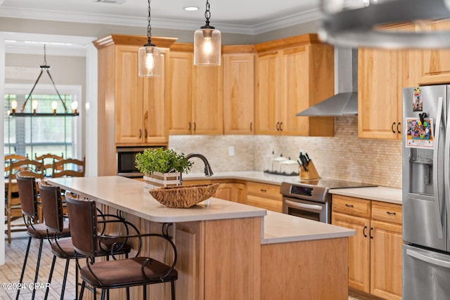 kitchen featuring wall chimney exhaust hood, a center island, stove, backsplash, and stainless steel fridge