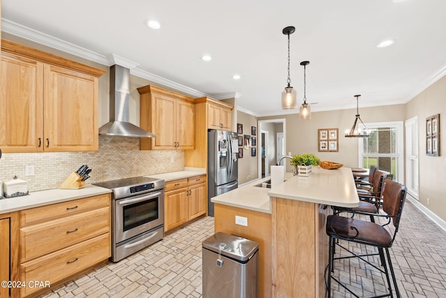 kitchen with wall chimney exhaust hood, range, a center island with sink, tasteful backsplash, and stainless steel fridge