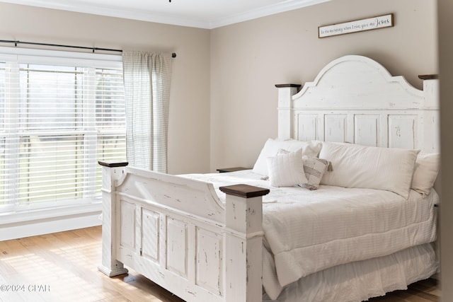 bedroom featuring ornamental molding, hardwood / wood-style floors, and multiple windows