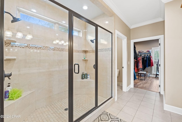 bathroom featuring ornamental molding, walk in shower, a healthy amount of sunlight, and tile floors