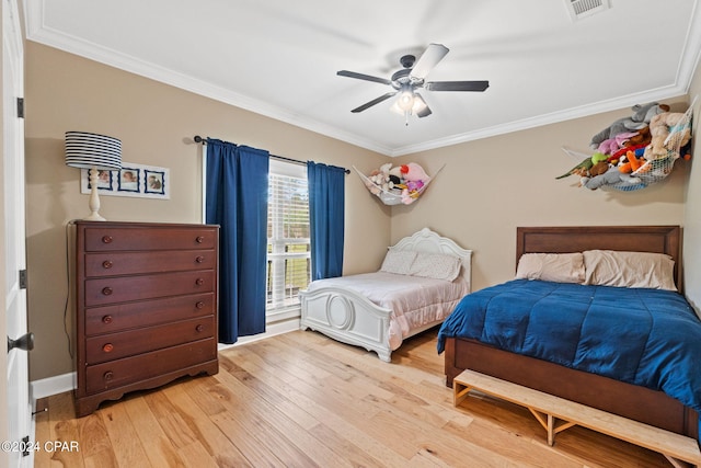 bedroom with ornamental molding, ceiling fan, and light wood-type flooring