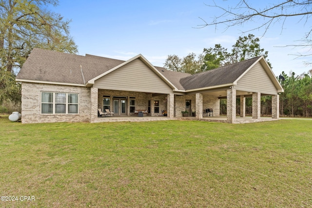 rear view of house with a lawn and a patio area