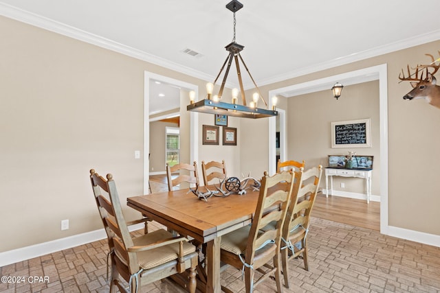 dining space with light hardwood / wood-style flooring, a chandelier, and crown molding