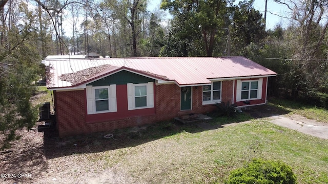 single story home with central AC unit and a front yard