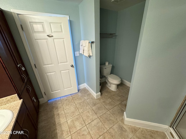 bathroom with vanity, toilet, an enclosed shower, and tile patterned floors