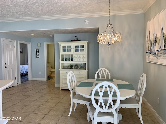 tiled dining room with ornamental molding, a notable chandelier, and a textured ceiling