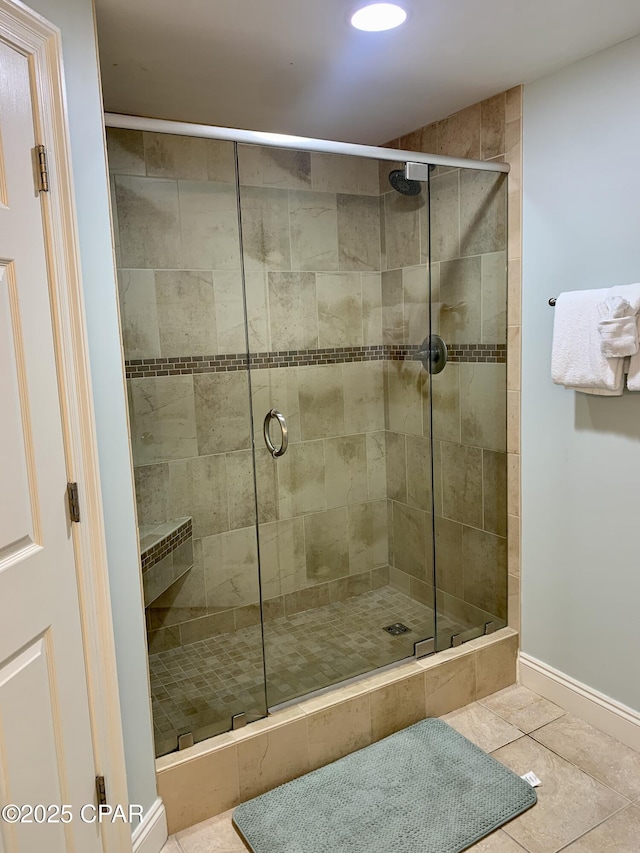 bathroom with tile patterned floors and a shower with door