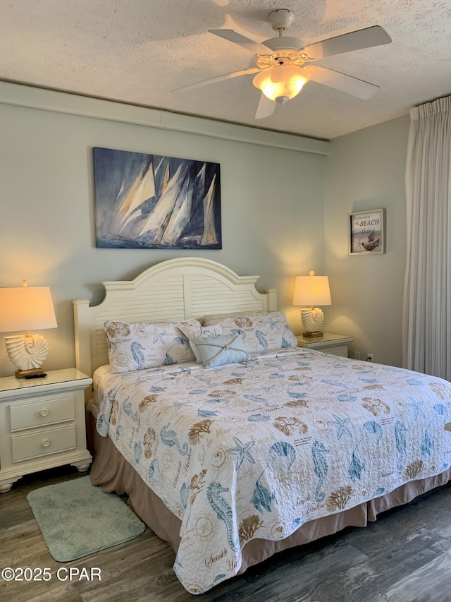 bedroom with dark wood-type flooring, ceiling fan, and a textured ceiling