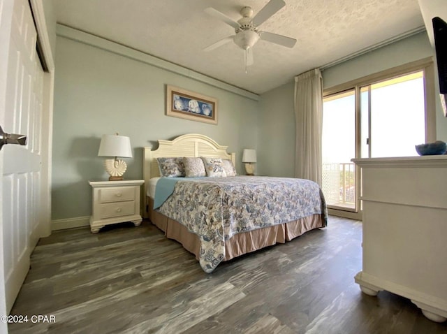 bedroom with ceiling fan, dark hardwood / wood-style flooring, and a textured ceiling