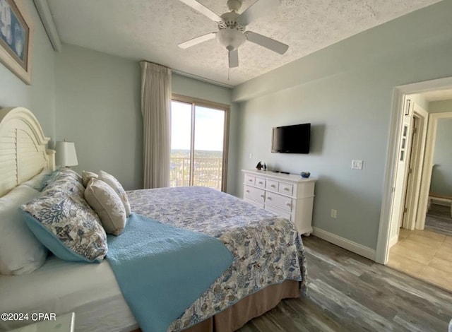 bedroom with hardwood / wood-style flooring, ceiling fan, access to outside, and a textured ceiling