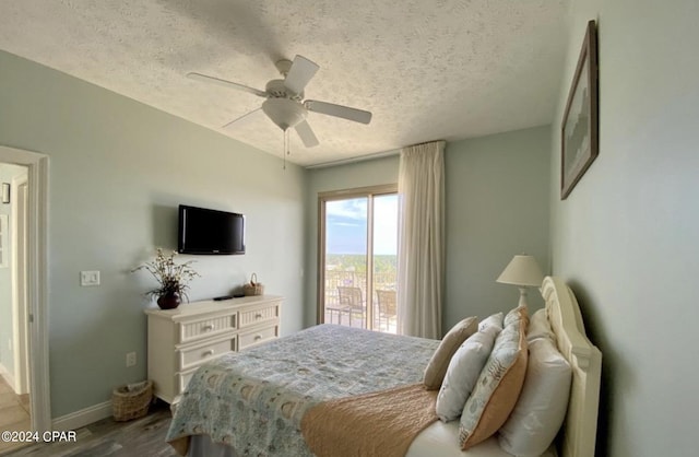 bedroom with ceiling fan, light hardwood / wood-style floors, and a textured ceiling