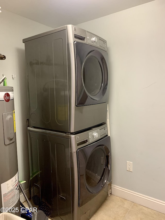 clothes washing area with stacked washer / drying machine, water heater, and light tile patterned floors