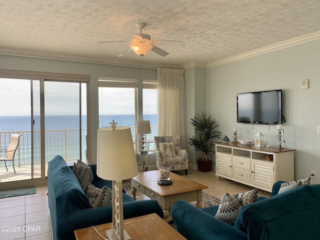 living room with a water view, a textured ceiling, light tile patterned floors, ornamental molding, and ceiling fan