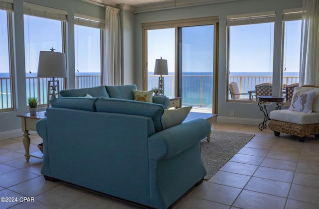 living room with light tile patterned floors, plenty of natural light, and a water view